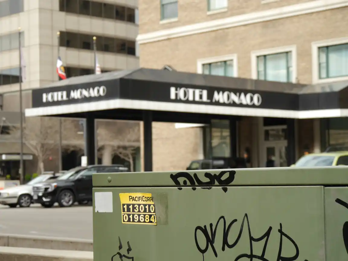 The Kimpton Hotel Monaco framed by a power transformer with graffiti