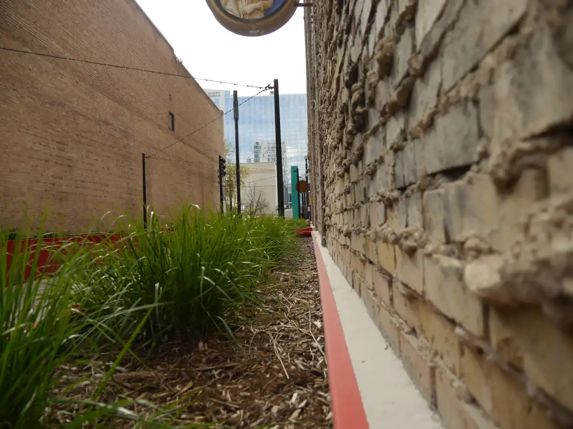 Planters and exposed grout pointing down an alley