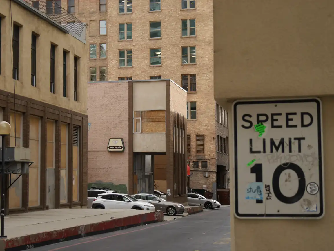 An alley framed by a 'SPEED LIMIT 10' sign