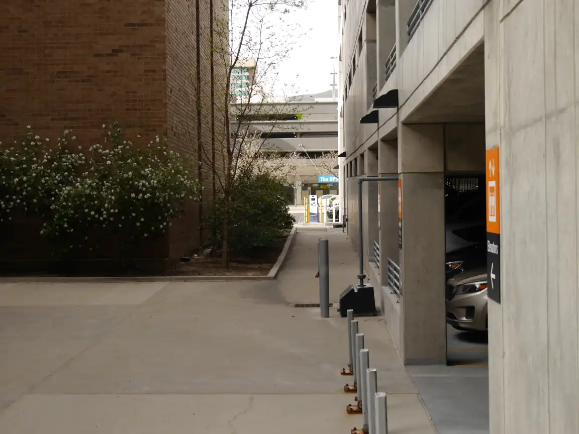 A pedestrian walkway leading out of American Plaza, next to the parking garage